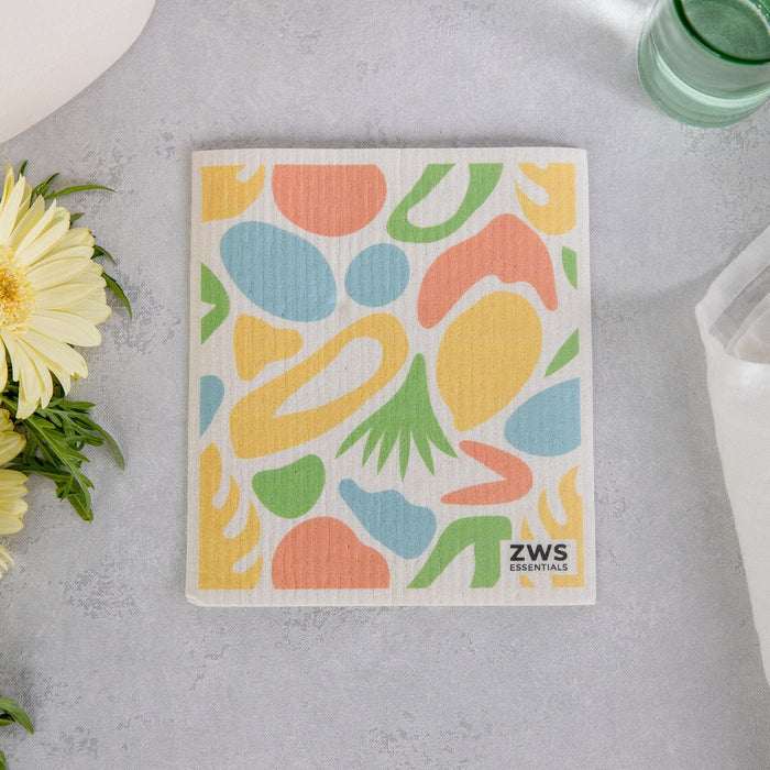 Two dry sponge clothes held up. Left image has oranges, right image has lemons