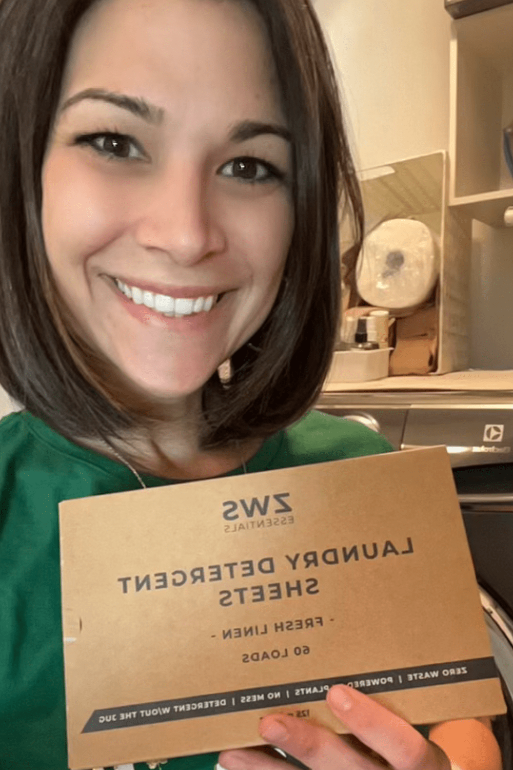 customer holding up laundry detergent sheets customer holding up laundry detergent sheets