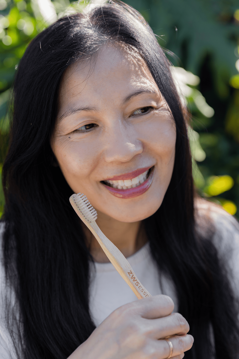 older women holding bamboo toothbrush