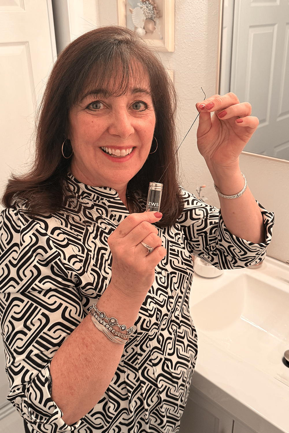 patti holding bamboo floss in bathroom patti holding bamboo floss in bathroom