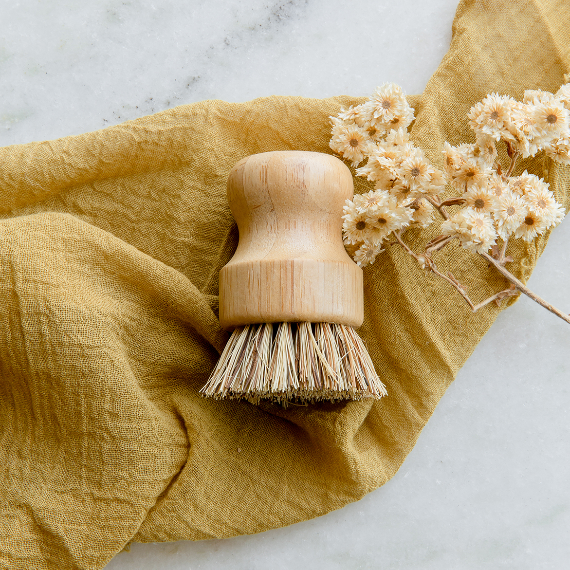 Pot Scrubber - Eco Friendly Dish Scrubber, Bamboo, Plastic Free, Compostable Bamboo pot scrubber with plant fiber bristles resting on tan muslin cloth